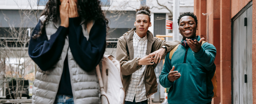 Two boys standing close to a girl, who looks uncomfortable, raising concerns about safety in public spaces; is Morocco a safe place to visit?