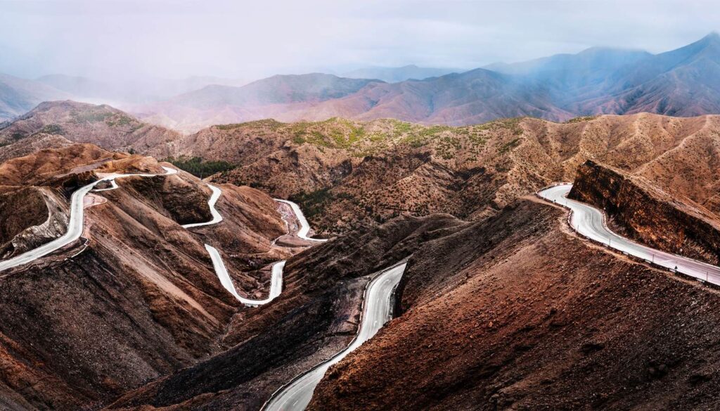 Winding road leading to the Atlas Mountains, a scenic journey for couples traveling in Morocco.