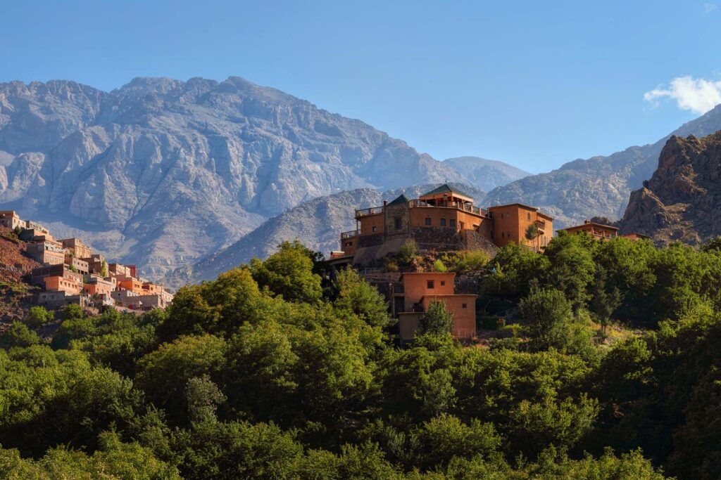 A stunning view of Kasbah du Toubkal in Imlil, nestled in the Atlas Mountains, showcasing traditional Moroccan architecture against a backdrop of majestic peaks, a perfect romantic spot in Morocco.