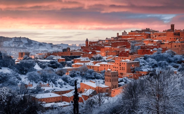 A stunning view of the Atlas Mountains covered in snow, perfect for people visiting Morocco in December.